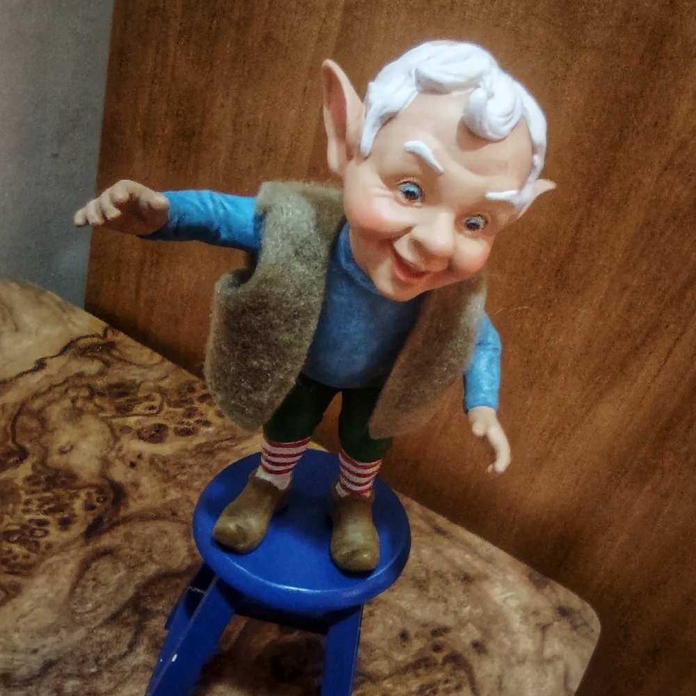 Elf standing on blue painted bench